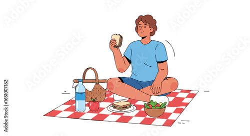 A young man sitting on a red and white checkered blanket enjoys a calm picnic experience outdoors on a sunny day