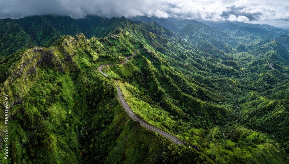 Naklejka premium Winding road through lush green mountain range