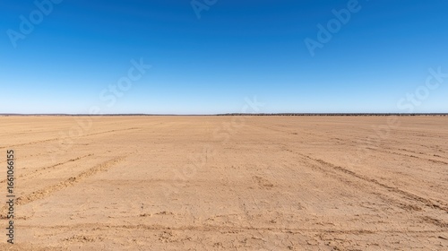 A vast  flat desert landscape under a clear blue sky.
