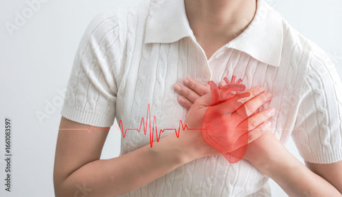 Fotografie Close up of woman suffering chest pain holding heart, heartbeat graph overlay, heart attack, cardiovascular disease, healthcare and medical concept, isolated on white background