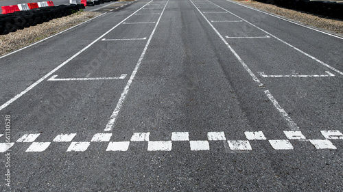 Fotografia Start and Finish motor race line asphalt on grand prix street circuit, Checkered line on racing motorsport race track, Auto or automobile background concept