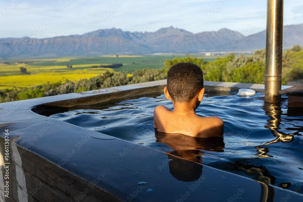 Fototapeta premium Boy in a hot tub with a Mountain View