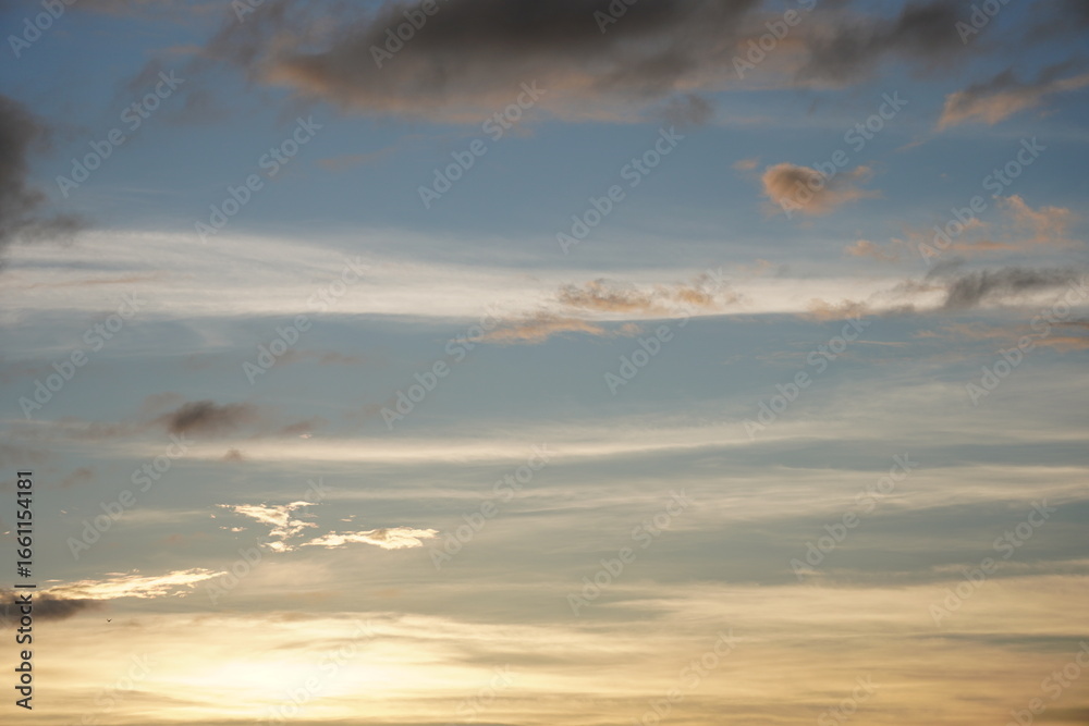 Fototapeta premium The dramatic sky with orange hue of sunlight, clouds are lining in the sky