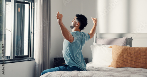 Stretching, wake up and morning with man in bedroom for routine, relax and rest or getting ready. Start of day, health and wellness with person in bed of home for peace, calm and comfort in house