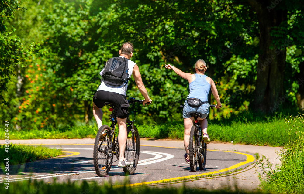 Naklejka premium Cyclists ride on the bike path in the city Park 
