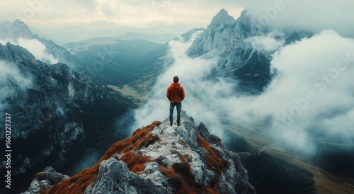 Person Standing on Mountain Peak Overlooking Misty Valley at Dawn