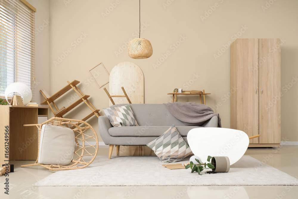 Obraz premium Interior of damaged living room with sofa and overturned furniture after earthquake