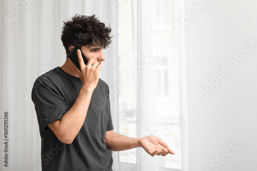 Young man talking by mobile...
