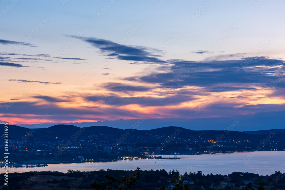 Fototapeta premium Sunrise colors breaking through clouds at Lake Balaton