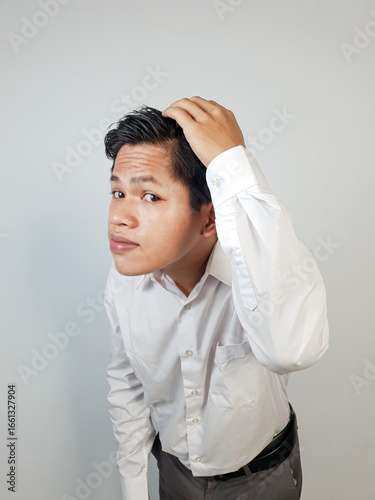 Canvas Print A young man in professional attire adjusts his hair, expressing casualness and thoughtfulness