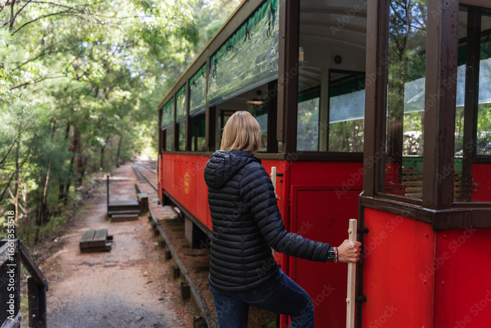 Φωτογραφία Woman hopping on a tram in the lush forest of south west Western Australia
