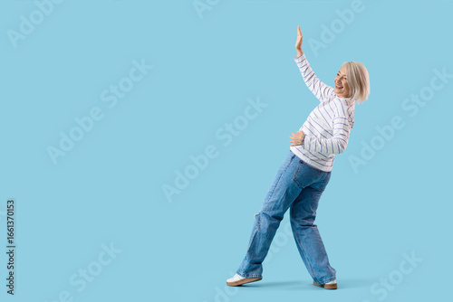 Mature woman dancing on blu...