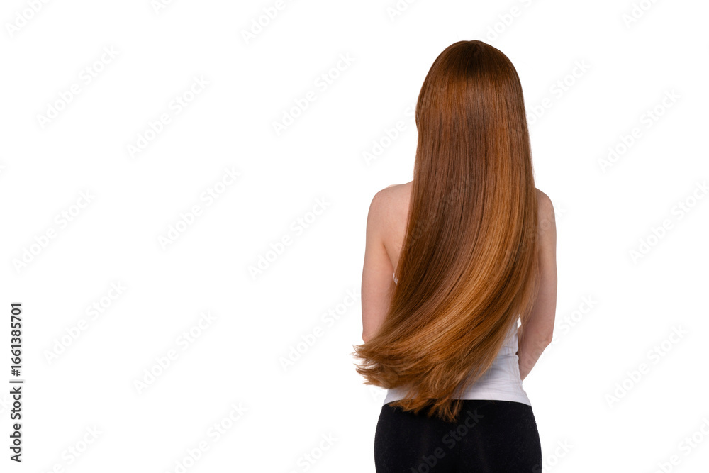 Naklejka premium Long, flowing red hair cascades down the back of a person standing against a plain background while wearing a simple top and black pants