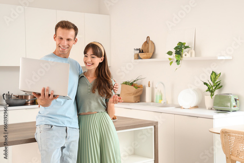 Young couple using laptop i...