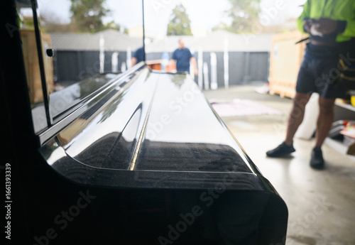 Unrecognizable workers preparing to move a piano. Concept of home moving and delivery.