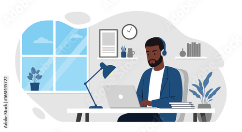 Focused Black man working remotely on a laptop in a modern home office with headphones. Represents productivity, remote work, and online education.