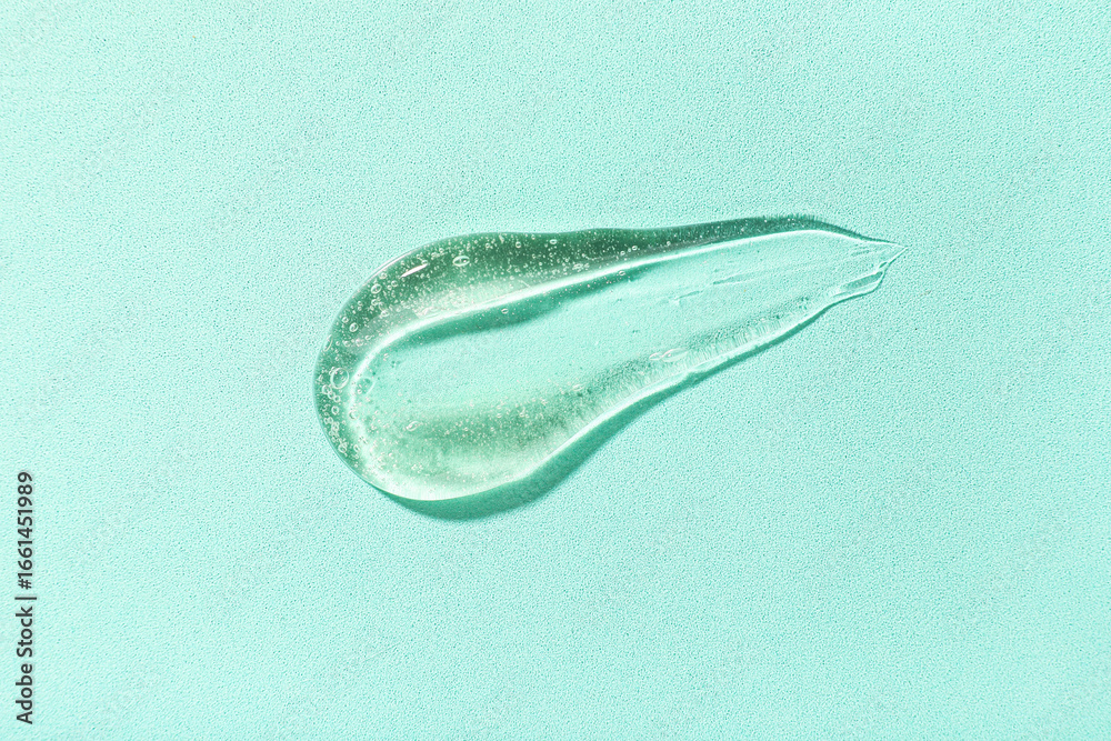 Obraz premium Sample of cosmetic gel on turquoise background, closeup