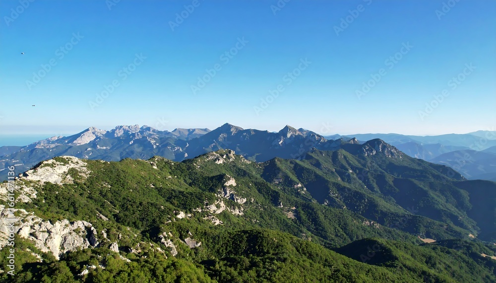 Obraz premium Majestic mountain vista rolling green hills with clear blue sky, and outdoor travel scenery.