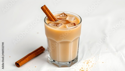 A refreshing iced coffee served in a glass, accompanied by cinnamon sticks and ice cubes