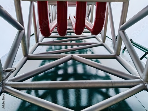 Industrial steel structure with red pipeline on green tank, engineering construction, refinery, petrochemical plant, factory piping system, structural design, heavy industry infrastructure, safety ins