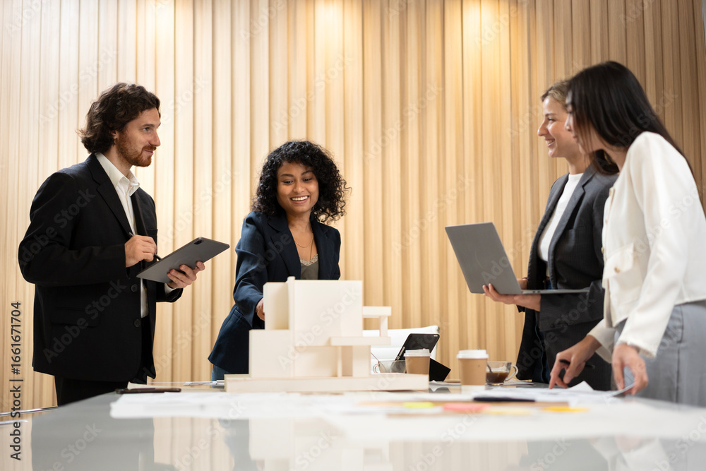 Fototapeta premium African businesswoman leading a meeting and presenting a housing project plan using a scale model to her colleagues in a modern office