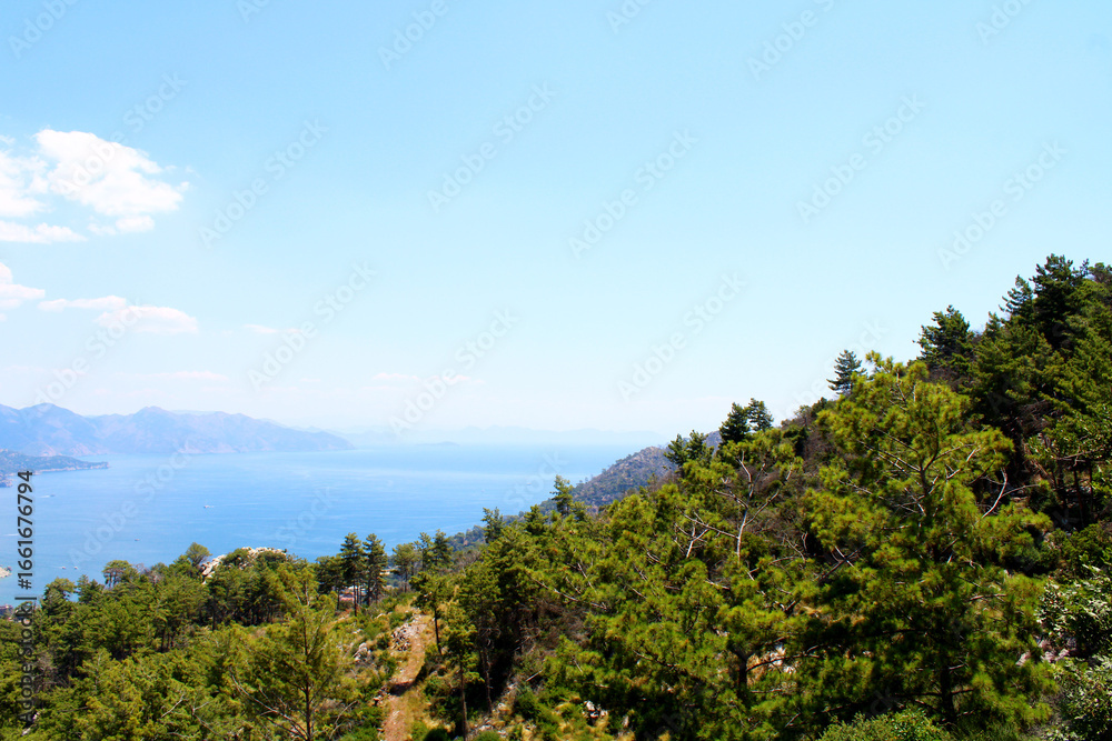Obraz premium Scenic coastal view with mountains and turquoise water under a bright sky. Marmaris, Mugla, Turkey.