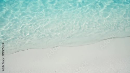 Serene tropical beach with crystal clear turquoise water gently lapping onto pristine white sand creating a peaceful and relaxing scene