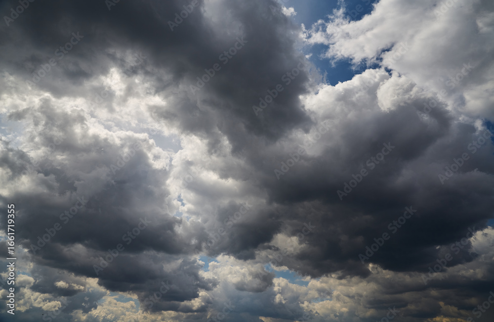 Obraz premium Dramatic cumulus clouds create a powerful effect against the blue sky, signifying change and movement. For news materials about climate.