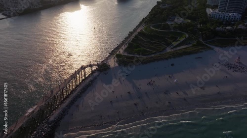 Wallpaper Mural Aerial reveal shot of cruise ship leaving Port of Miami at sunset. People relaxing on South Beach tropical waterfront, Miami skyline and high-rise buildings in view. Perfect for travel and vacation  Torontodigital.ca