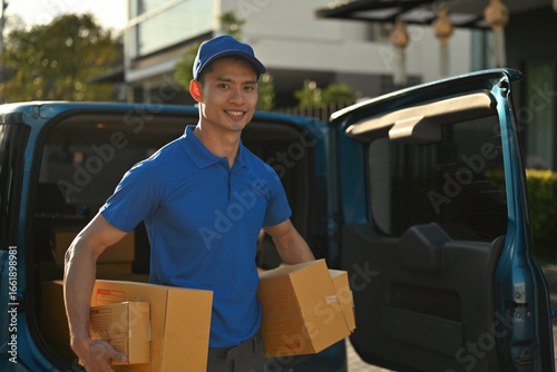 A Young parcel courier confidently delivers boxes from a van during a sunny workday.