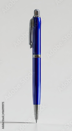 A sleek, cobalt blue pen with a metallic silver clip and accents stands upright against a neutral white background, casting a subtle shadow
