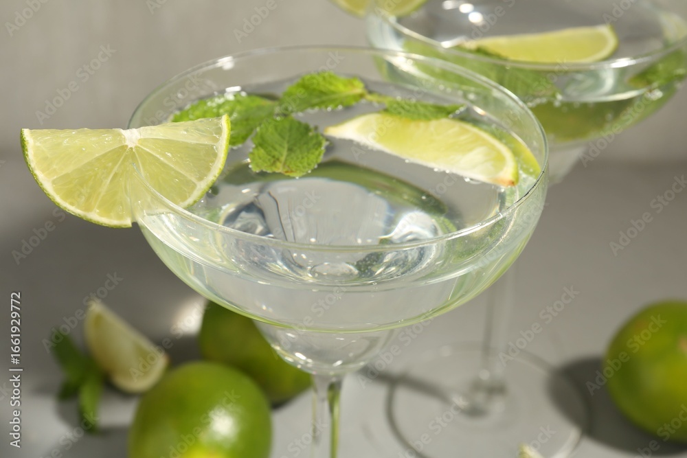 Fototapeta premium Martini cocktails with lime and mint on grey table, closeup