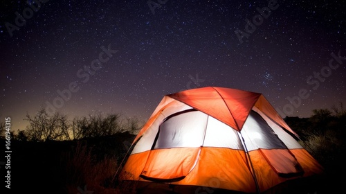 A bright orange tent stands out under a starry night sky, with warm light glowing from inside,