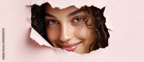 The Beautiful Woman Peeking Through a Torn Pink Background