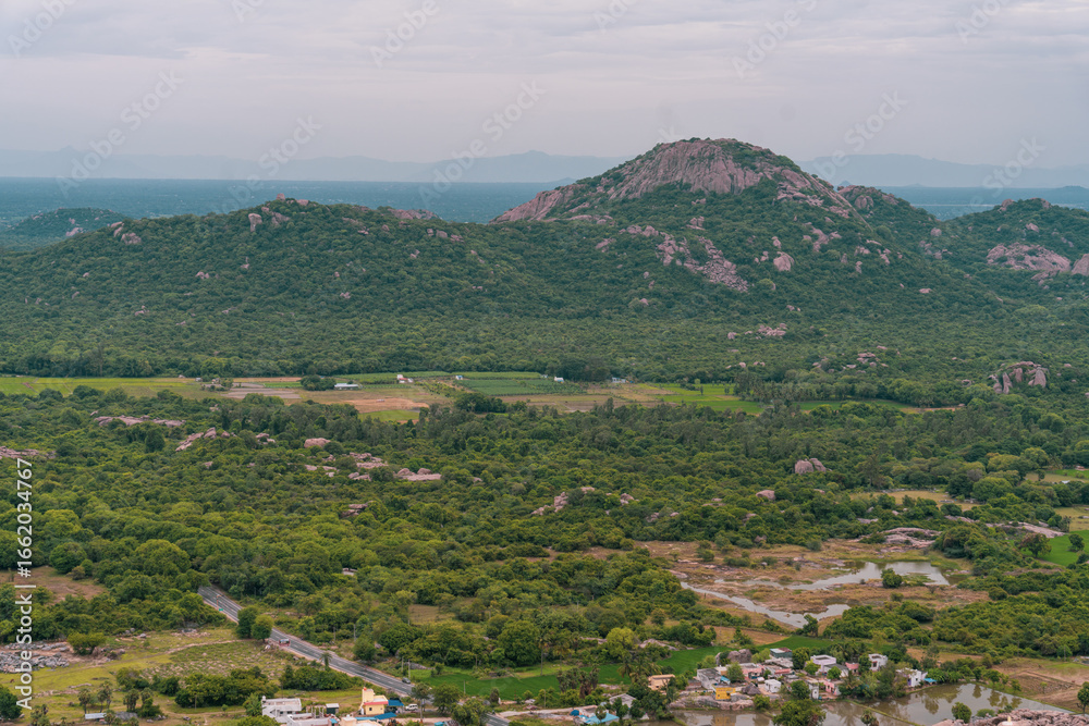 Fototapeta premium A mountain range with a green forest in the foreground