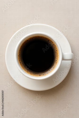 White cup filled with hot black coffee served on light background top view minimal style