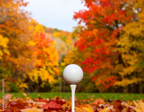 A golf ball ready for play amidst the stunning colors of autumn