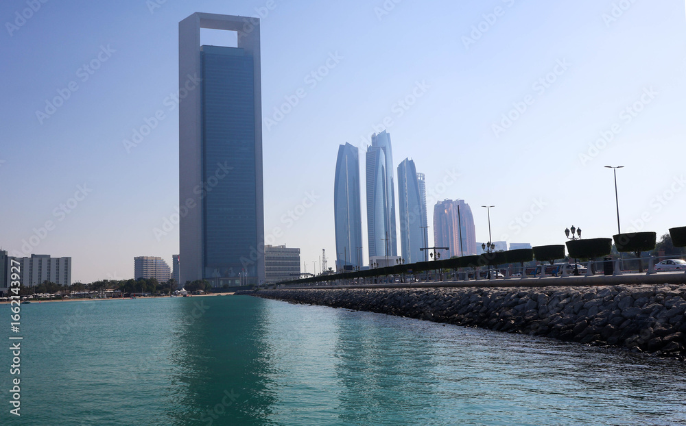 Obraz premium Modern Abu Dhabi skyline with high-rise towers, wide streets, and city lights showcasing the UAE’s capital’s urban beauty.