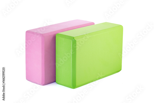 Green and pink polypropylene yoga block isolated on white background. Sports and health products.