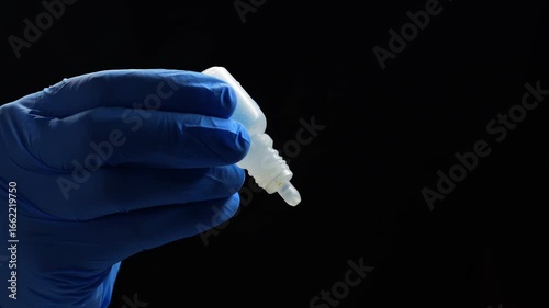 Doctor in blue gloves holds a bottle of eye drops.
Treatment of poor grain and dry eyes.
Dry eyes from sitting at a laptop for a long time.
Ophthalmology concept
