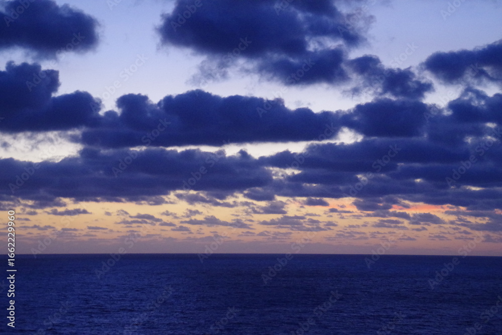 Obraz premium Purple clouds over the sea at sunset