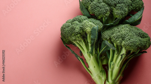 Fresh green broccoli in flat lay composition on color background with space for text.

