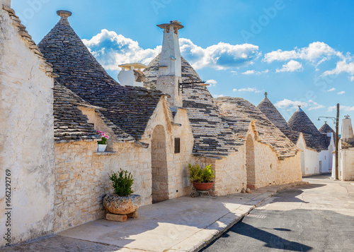 Street in Alberobello village with traditional trulli houses.