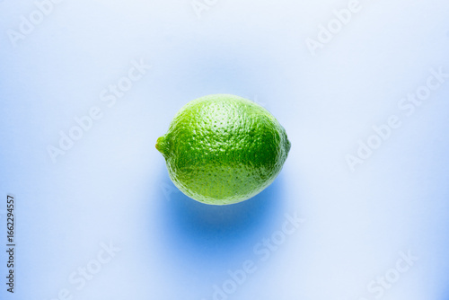Fresh bright green lime on a blue background.