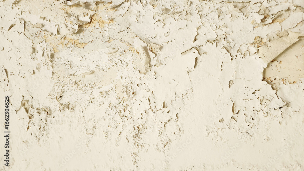 Fototapeta premium Wall surface with peeling, cracked, and damaged paint due to moisture and water damage