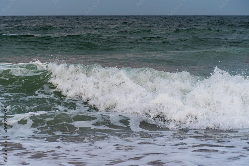 Fototapeta premium Powerful ocean wave crashing with foamy splash close up view