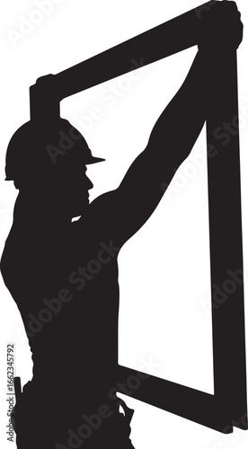Silhouette of construction worker in hard hat installing window frame installation