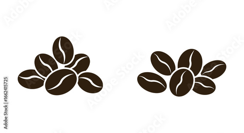 Brown coffee beans in two piles on a white background