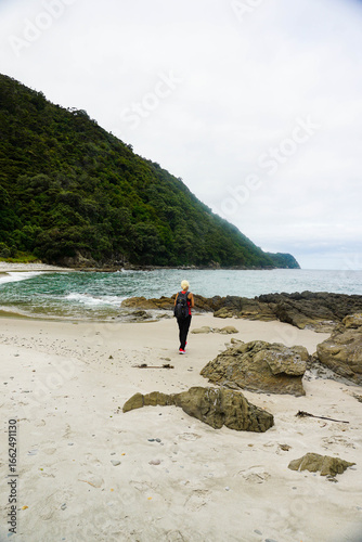 A woman walks around Smugglers Bay, Whangārei Heads, New Zealand.