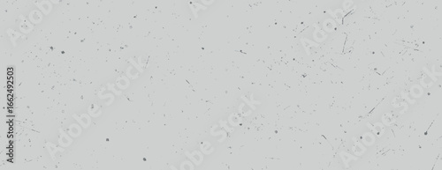 Gray background with a speckled texture. The background is gray with scattered black specks, creating a subtle, textured look. Paper texture background vector. Gray background.
